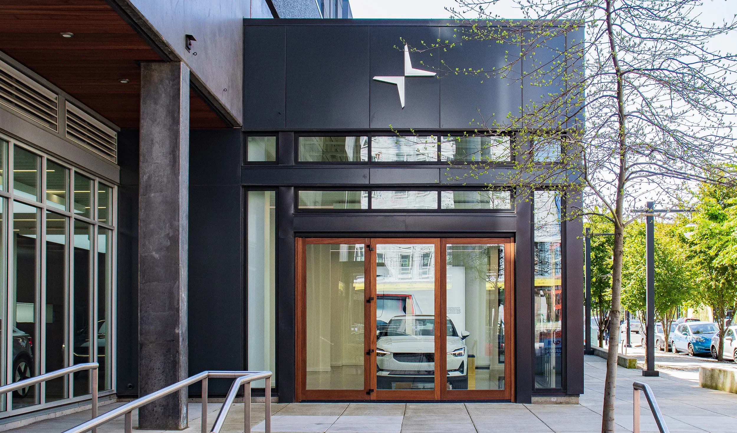 A dark-clad retail showroom frontage with a lit interior behind full-height glazing
