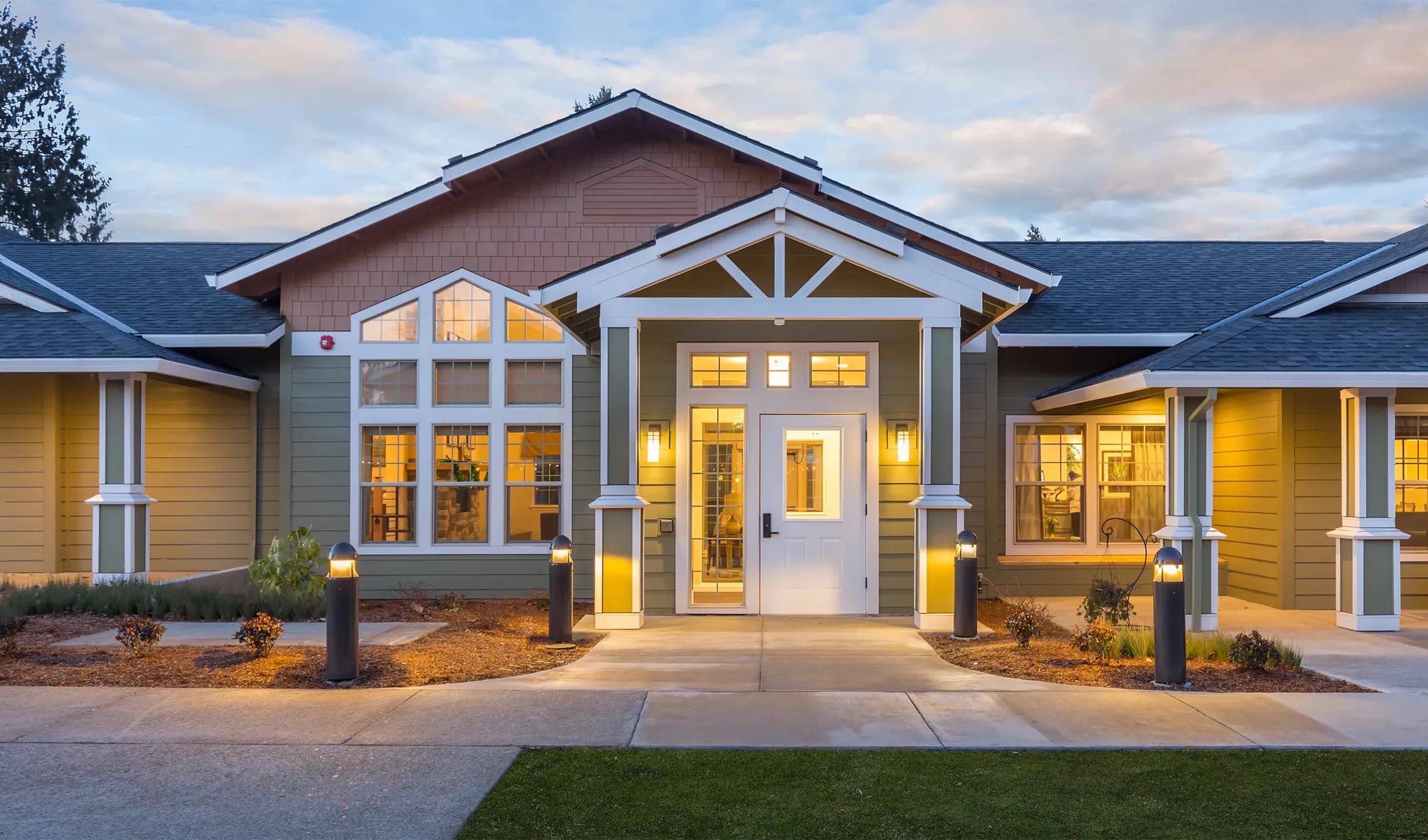 Craftsman home at dusk with exterior and interior lighting on