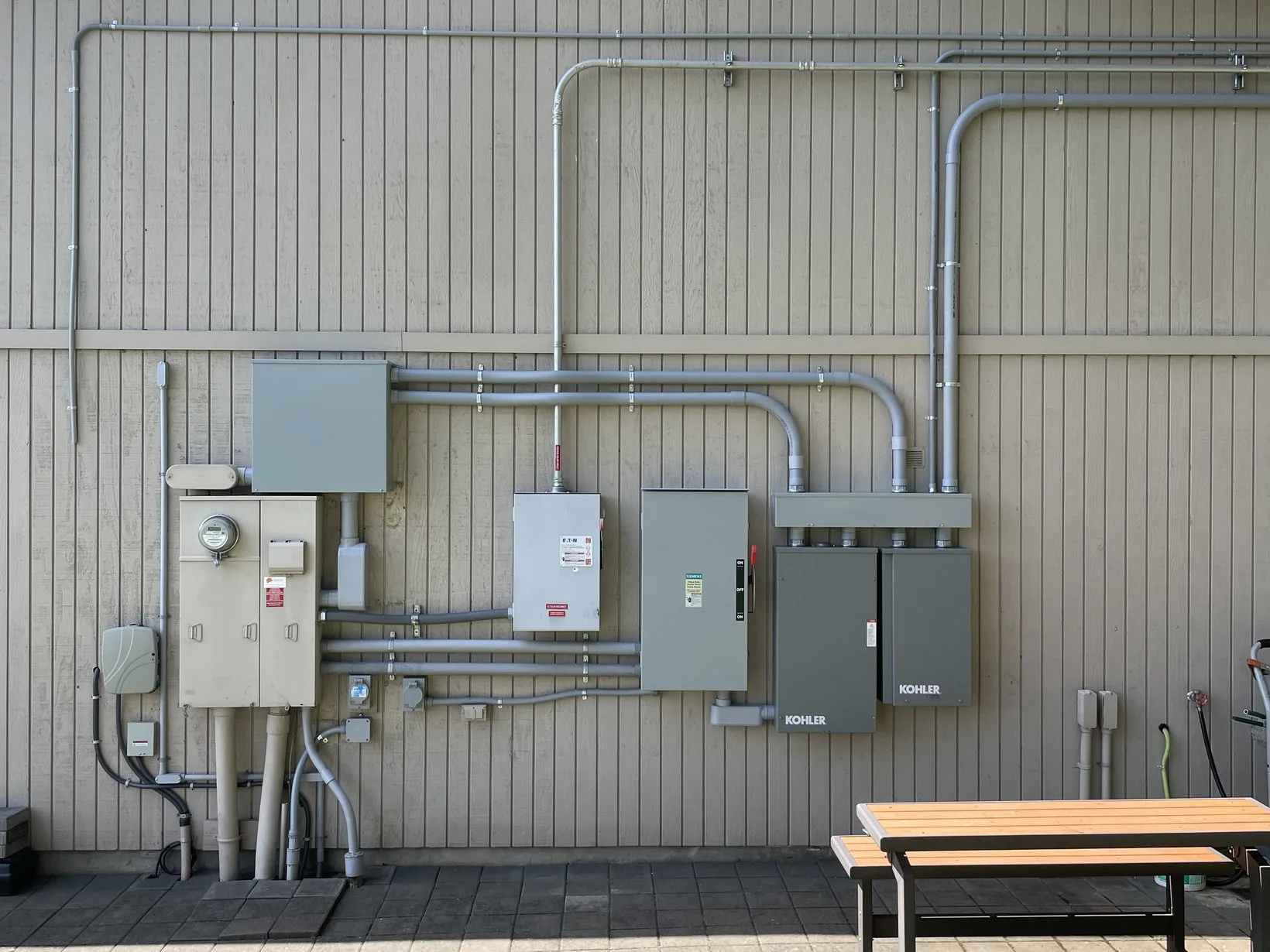 An upgraded electrical service: meter, disconnects and conduit runs mounted on a building exterior
